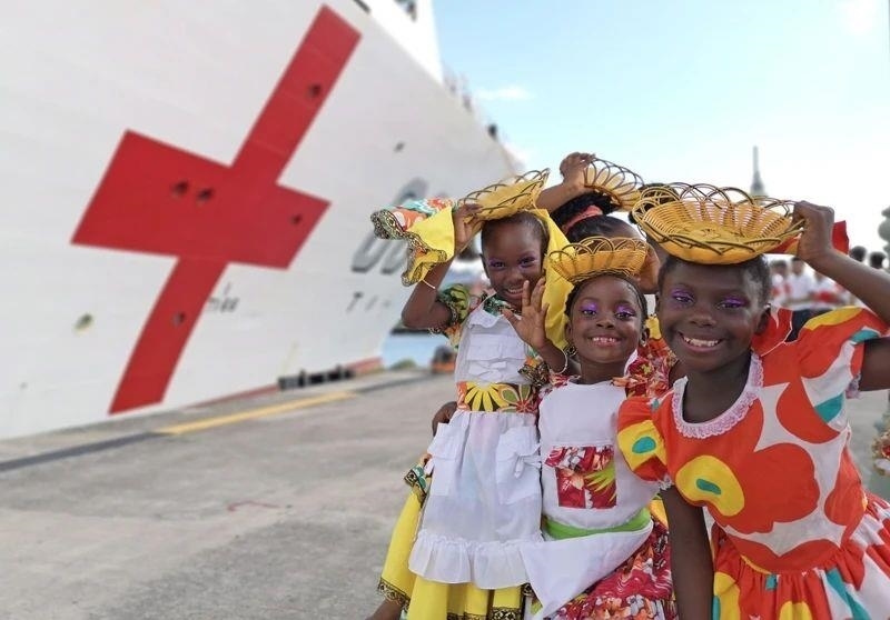 2018年10月，在安提瓜和巴布達首都圣約翰，當?shù)匦∨笥焉泶﹤鹘y(tǒng)服裝歡迎中國海軍“和平方舟”醫(yī)院船首次到訪。