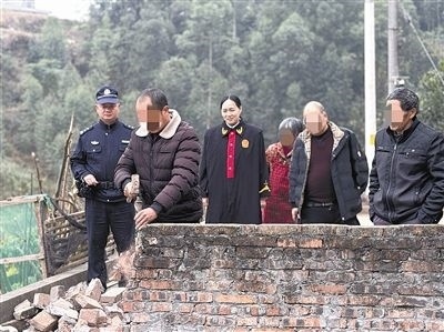  圖③：庭審結(jié)束后，在法官的見證下，陳某在院壩邊重新開鑿一條通道。