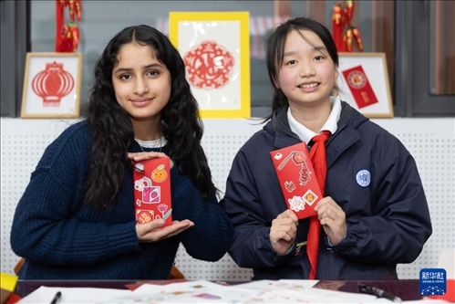 1月28日，美國(guó)馬斯卡廷中學(xué)學(xué)生（左）和復(fù)旦大學(xué)第二附屬學(xué)校學(xué)生展示互相送出的寫有寄語祝福的紅包。 新華社記者 王翔 攝