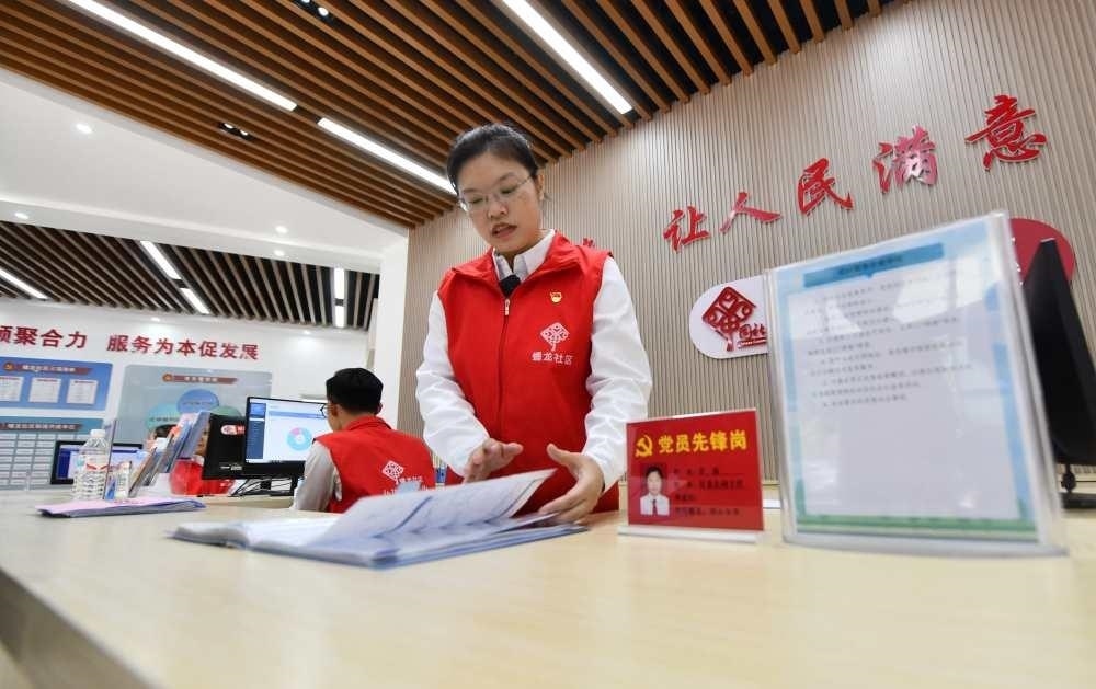 △2023年12月14日，廣西南寧市蟠龍社區(qū)，工作人員在為居民服務(wù)。