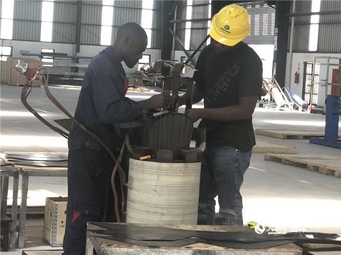 經(jīng)貿(mào)合作區(qū)廠房?jī)?nèi)，當(dāng)?shù)毓と苏诰o張作業(yè)。人民網(wǎng)記者 黃培昭攝