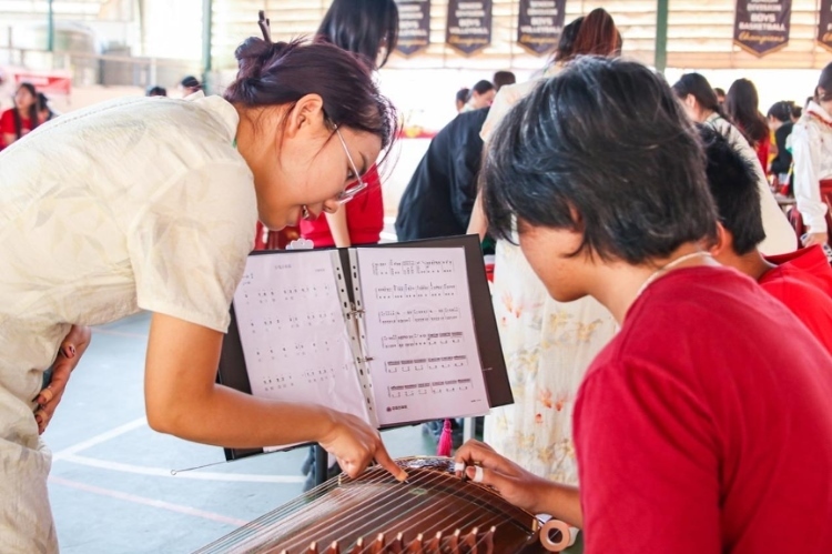 志愿者教師指導(dǎo)學(xué)生彈奏古箏?；顒?dòng)主辦方供圖