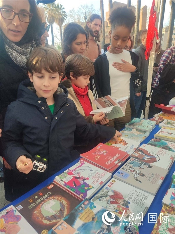 印刷精美的中國傳統(tǒng)文化叢書吸引了小游客的注意。人民網(wǎng)記者鄭彬攝