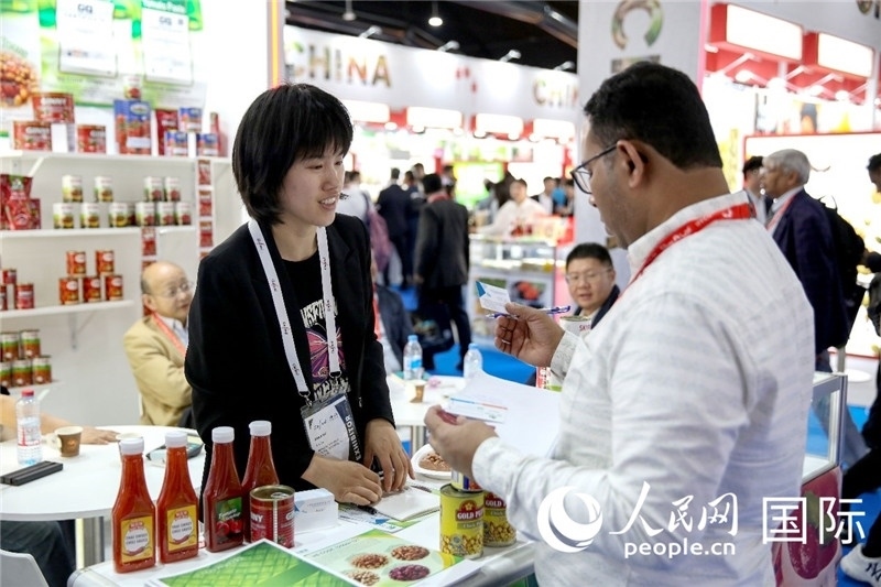 圖為中國參展企業(yè)代表與采購商交流。人民網(wǎng) 塔里克·易卜拉欣攝