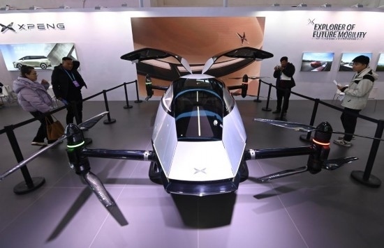 2023年12月1日，在鏈博會智能汽車鏈展區(qū)小鵬汽車展臺，參觀者觀看一臺智能飛行器。新華社記者蔡湘鑫攝