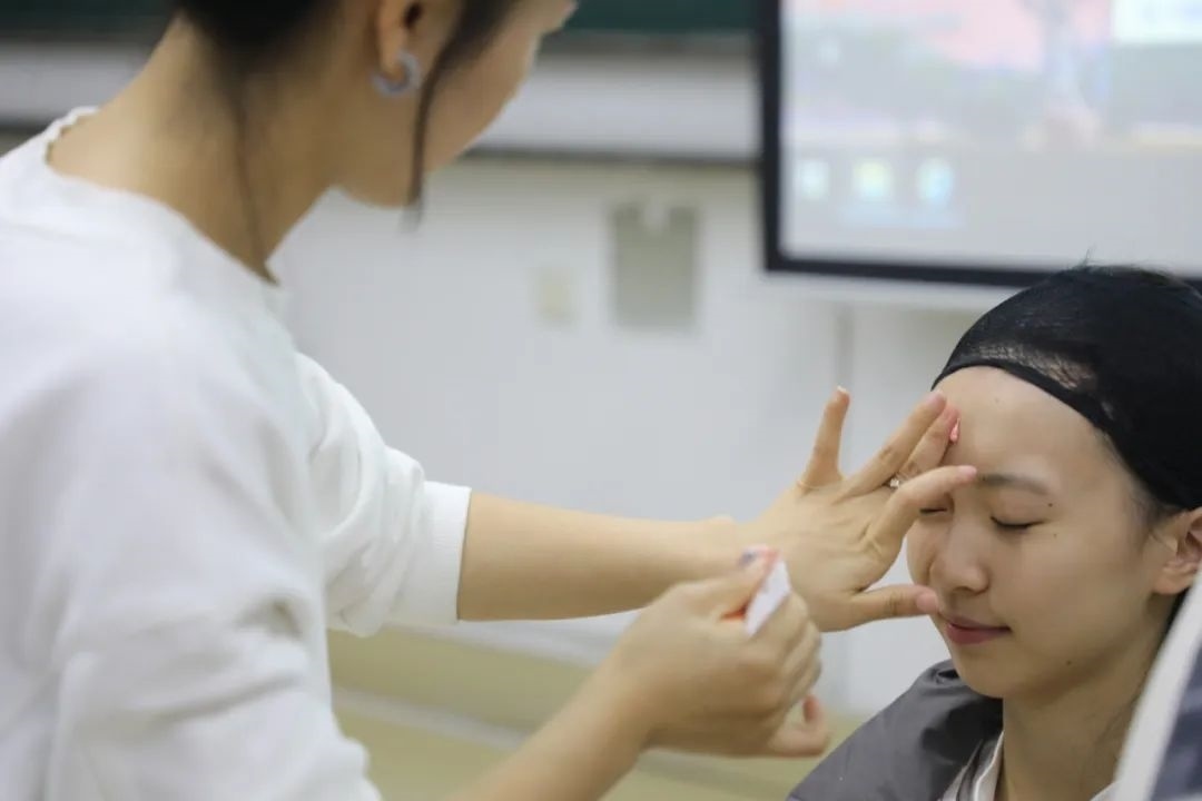 課堂上，一名學(xué)生在體驗(yàn)上戲妝。學(xué)校供圖