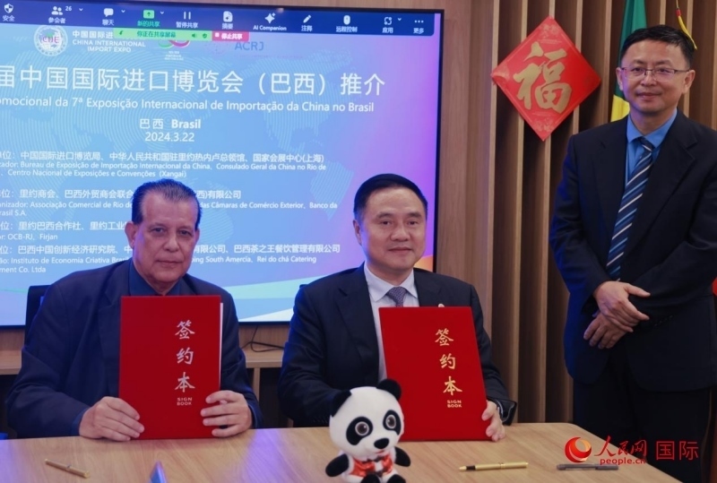 巴西外貿(mào)商會(huì)聯(lián)合會(huì)會(huì)長阿代爾·羅伯托（左）與中國國際進(jìn)口博覽局副局長吳政平（中）現(xiàn)場(chǎng)簽訂協(xié)議。人民網(wǎng)記者 宋亦然攝