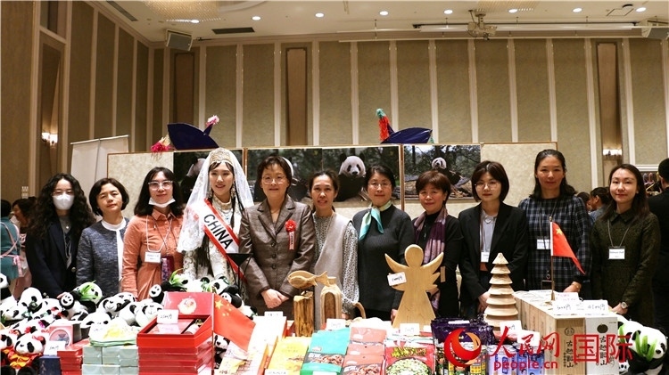 中國駐日本大使吳江浩夫人丁玥（左五）與使館人員在展位前合影留念。人民網 許可攝