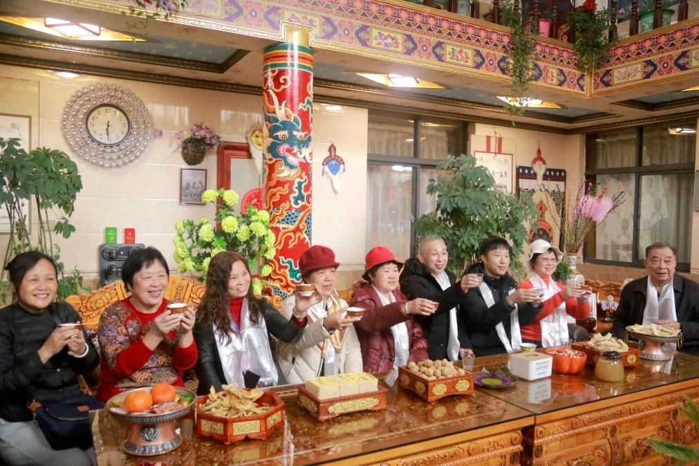 游客們?nèi)胱∶袼藓螅e杯共飲酥油茶。新華社記者 邱星翔 攝