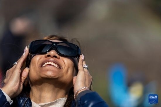 4月8日，一名女子在美國(guó)紐約州普拉茨堡觀看日食。新華社發(fā)（文森特·約翰遜攝）