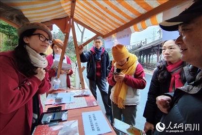 1月6日，“2024成都蒲江柑甜采摘節(jié)”上，記者見到了小萌（左一）和許多年輕人忙著做訪客接待、現(xiàn)場布置、票務(wù)核對、采摘服務(wù)等工作。人民網(wǎng)記者朱虹攝