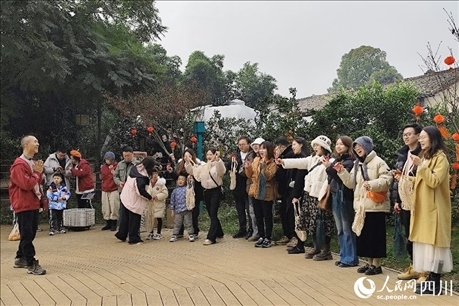 葉科（左一）給前來參與活動的“柑爸柑媽”介紹生態(tài)種植果。人民網(wǎng)記者朱虹攝