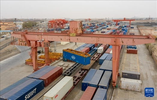 4月21日，二連浩特鐵路口岸龍門吊吊裝中歐班列集裝箱（無人機(jī)照片）。 新華社發(fā)（張海峰攝）