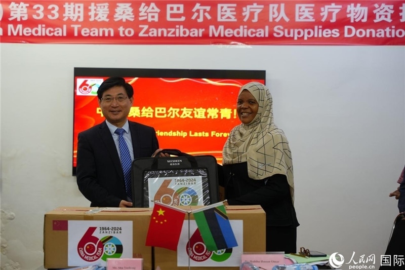 江蘇省蘇北人民醫(yī)院黨委書記束余聲捐贈物資與桑衛(wèi)生部首席秘書哈比巴。中國援桑醫(yī)療隊供圖