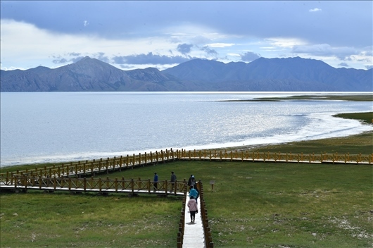 △ 游客行走在青?，敹嗫h冬格措納湖畔的木棧道上。