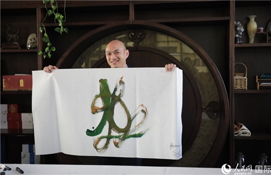 老撾駐華大使館三秘明君參加《五百筆·瀾湄合作》集體藝術(shù)創(chuàng)作。人民網(wǎng)王婧攝。