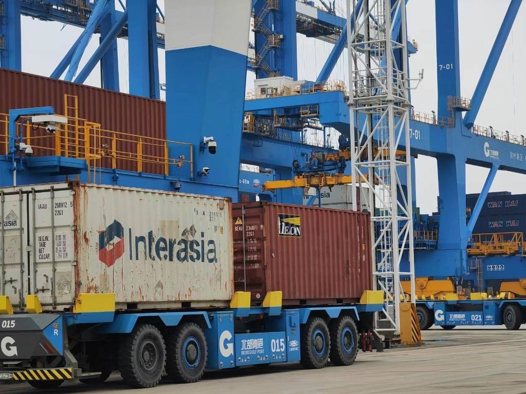 在欽州自動(dòng)化集裝箱碼頭，智能導(dǎo)引運(yùn)輸車在運(yùn)送集裝箱。新華社記者趙歡 攝