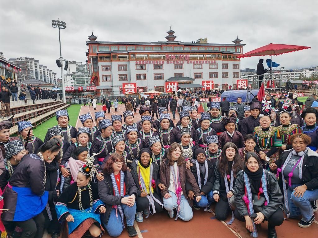 法國青年在“村超”賽場邊與參加表演的村民合影。新華社記者 羅羽 攝