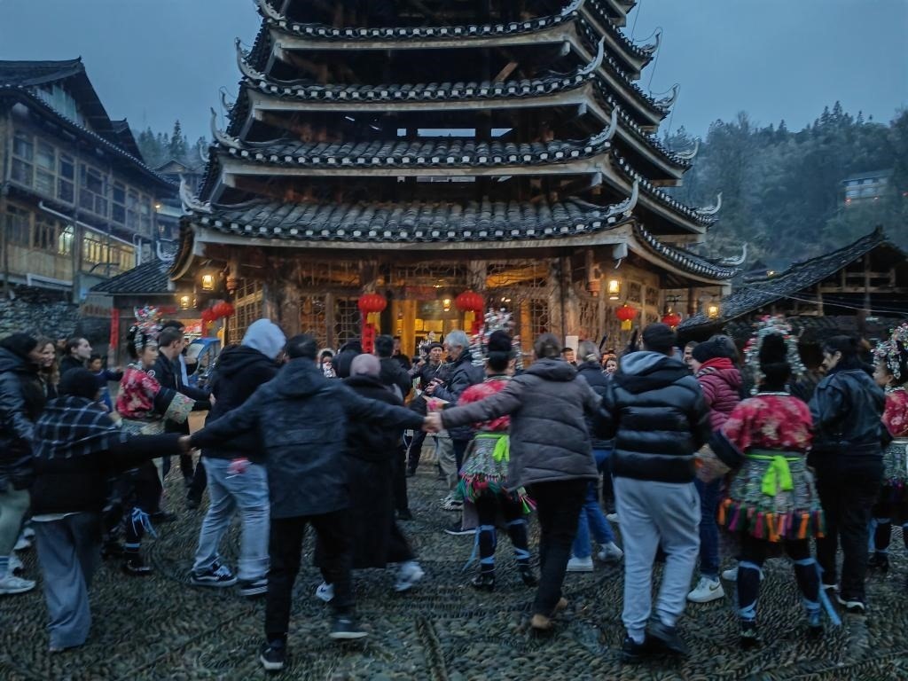 法國青年與當?shù)卮迕駹渴痔?。新華社記者 羅羽 攝