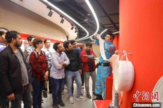 5月9日，工作人員指導(dǎo)留學(xué)生正確使用消防水帶。張鷹 攝