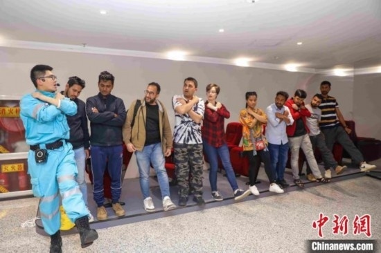 5月9日，工作人員指導(dǎo)留學(xué)生練習(xí)逃生技巧。張鷹 攝