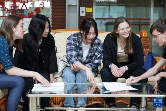 4月28日，宋智孝（右二）和胡靈月（左一）在北京首都師范大學(xué)校園內(nèi)與同學(xué)交流。新華社記者 彭子洋 攝