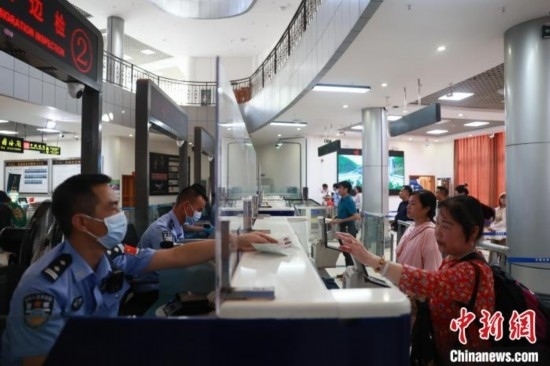圖為旅客在磨憨口岸辦理通關(guān)手續(xù)。雷雨 攝