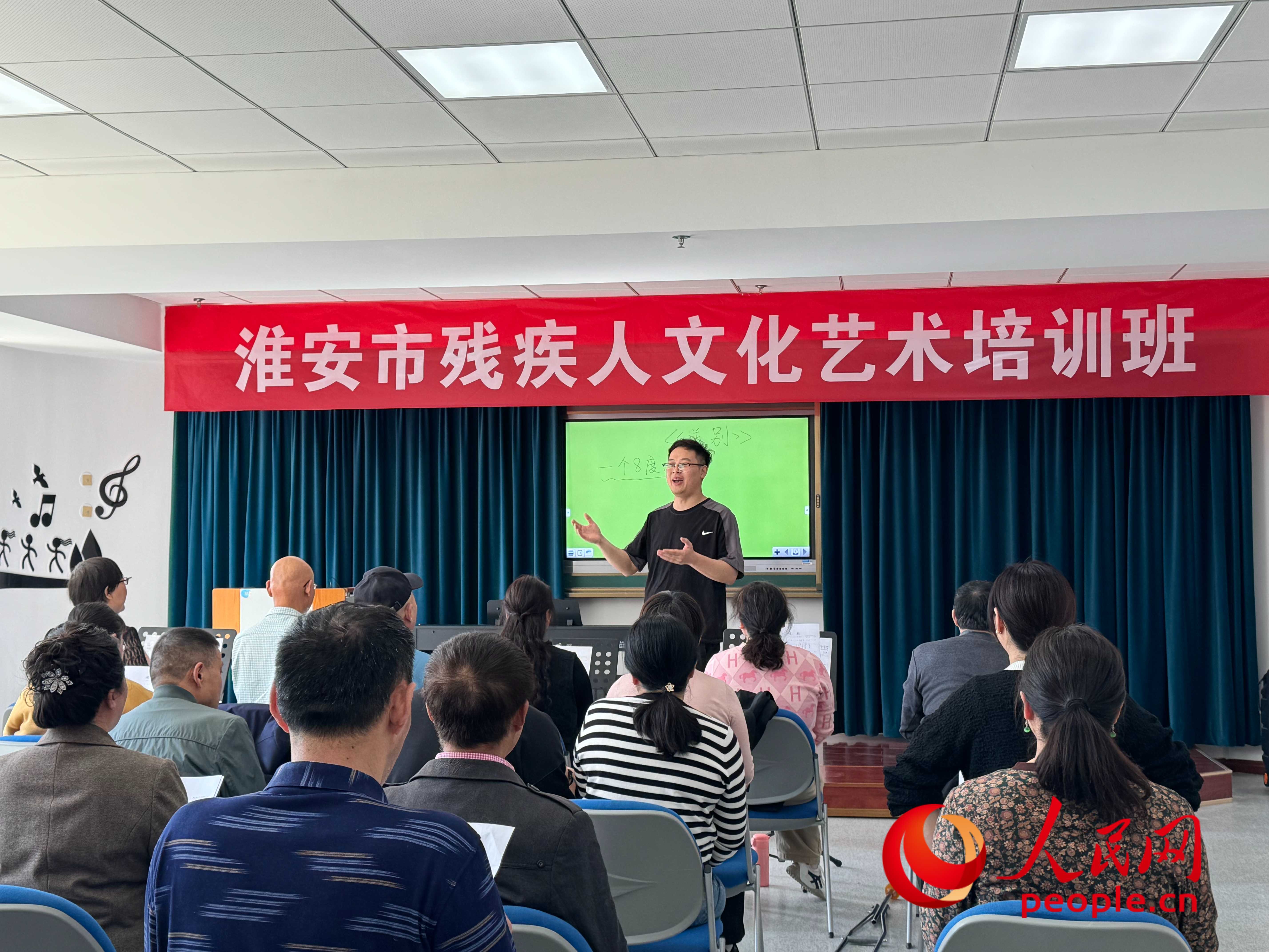 在淮安市殘疾人文化藝術(shù)培訓(xùn)班上，聲樂老師在教殘疾人唱《送別》這首歌曲。人民網(wǎng) 周靜圓攝