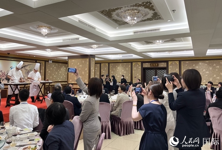 國家級非物質(zhì)文化遺產(chǎn)、全聚德片鴨工藝吸引代表團(tuán)成員拍照留念。