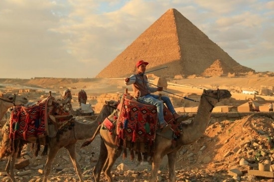 1月24日，商販騎駱駝離開埃及吉薩金字塔景區(qū)。新華社記者 隋先凱 攝