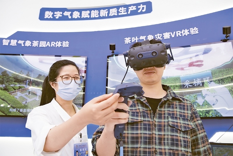 2024年5月23日，第七屆數(shù)字中國建設(shè)峰會現(xiàn)場體驗區(qū)在福州海峽國際會展中心向?qū)I(yè)觀眾開放。本次現(xiàn)場體驗區(qū)圍繞本屆峰會主題“釋放數(shù)據(jù)要素價值，發(fā)展新質(zhì)生產(chǎn)力”，設(shè)置“數(shù)字惠民”、“數(shù)字能力”、“數(shù)字基礎(chǔ)”、“數(shù)字生態(tài)”、“數(shù)字賦能”五大板塊。圖為一名觀眾（右）在數(shù)字氣象賦能新質(zhì)生產(chǎn)力展臺上進行體驗。 新華社記者 魏培全/攝