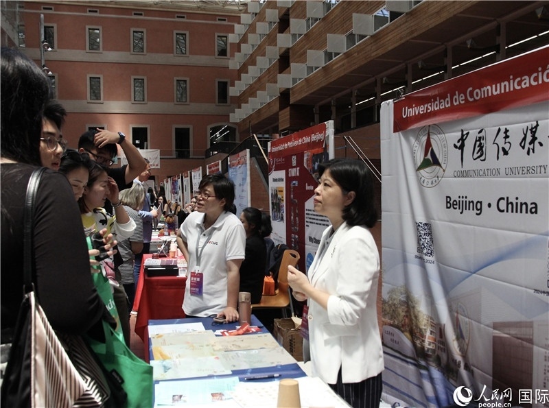 旅西華人華僑在展臺(tái)前咨詢。人民網(wǎng)記者 許海林?jǐn)z