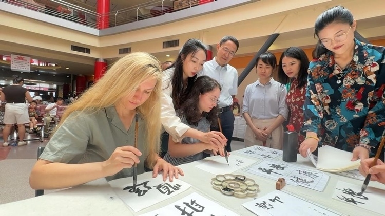 羅馬尼亞友人在活動(dòng)現(xiàn)場(chǎng)學(xué)寫漢字。中國(guó)駐羅馬尼亞大使館領(lǐng)僑處供圖