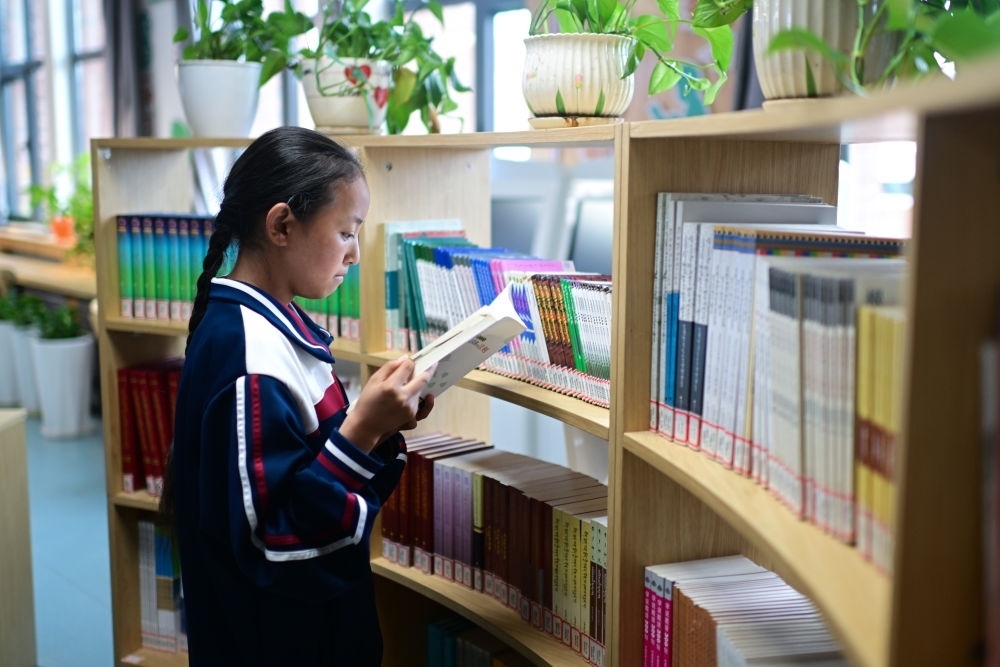 6月18日，果洛西寧民族中學(xué)學(xué)生尼東拉毛在圖書(shū)室看書(shū)。