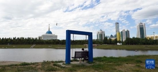 6月30日，一名女子在哈薩克斯坦首都阿斯塔納伊希姆河畔休息。新華社記者 王建華 攝