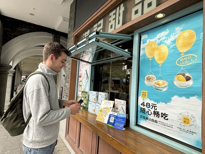 來(lái)自德國(guó)的留學(xué)生理查德在杭州西湖邊一家商鋪使用支付寶掃碼支付（2024年4月11日攝）。新華社發(fā)