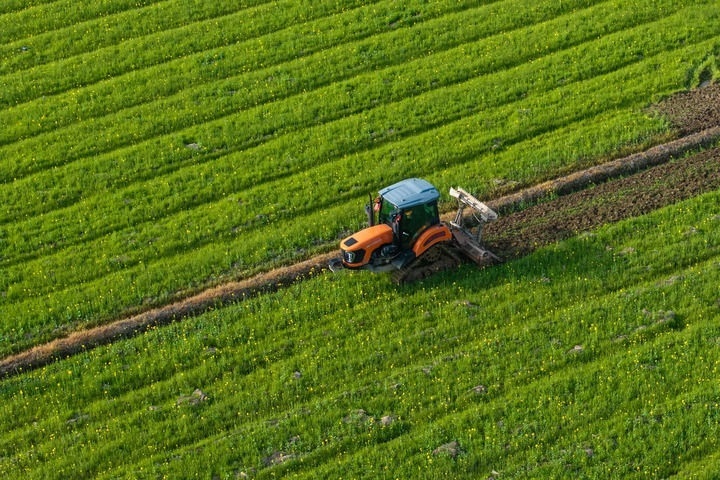2024年3月19日，在湖南省常德市鼎城區(qū)謝家鋪鎮(zhèn)港中坪村，村民駕駛農(nóng)機(jī)翻耕田地（無人機(jī)照片）。新華社記者 陳思汗 攝