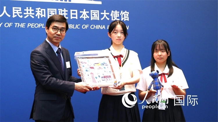 日本小大使向中國駐日本大使館臨時(shí)代辦施泳贈(zèng)送當(dāng)?shù)靥厣Y品。人民網(wǎng) 許可攝