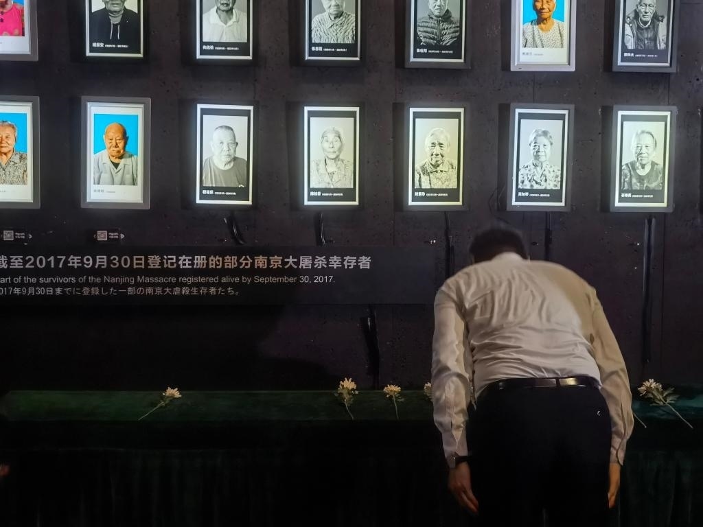 7月18日，人們向離世的南京大屠殺幸存者獻花、鞠躬。新華社記者邱冰清 攝