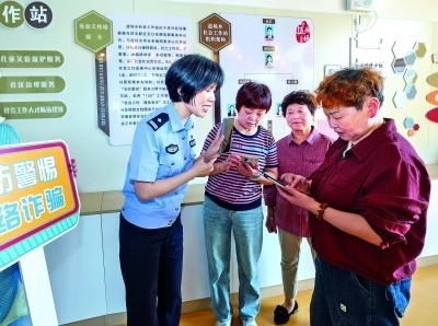 浙江湖州民警指導(dǎo)居民加入湖州“e企安”微信群，實(shí)時(shí)接收反詐信息。新華社發(fā)