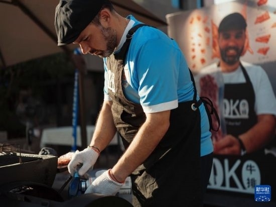 7月19日，在蕪湖古城，馬丁在當天舉行的啤酒節(jié)上制作牛排。新華社發(fā)（繆雨晨 攝）