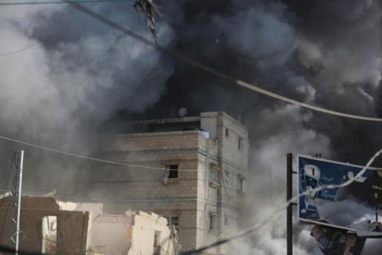 7月21日，在加沙地帶中部的努賽賴特難民營，遭以軍空襲的建筑冒出滾滾濃煙。新華社發(fā)（馬爾萬·達烏德攝）