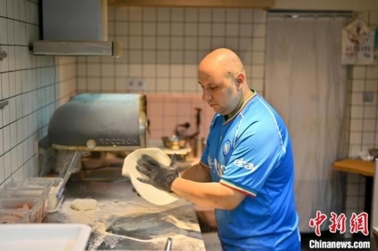 近日，韋榮耀在自家披薩小店內(nèi)忙活。俞靖 攝