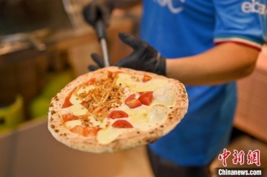 近日，韋榮耀展示他制作的“老友味”披薩。 俞靖 攝