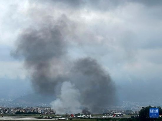這是7月24日在尼泊爾加德滿(mǎn)都特里布萬(wàn)機(jī)場(chǎng)拍攝的濃煙。目擊者說(shuō)，一架飛機(jī)在尼泊爾加德滿(mǎn)都特里布萬(wàn)機(jī)場(chǎng)墜毀。新華社/美聯(lián)