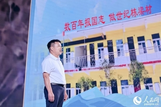 張玉滾分享用一根扁擔(dān)送孩子們走出大山的故事。人民網(wǎng)攝