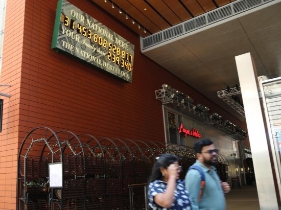 2023年5月29日，人們經(jīng)過美國(guó)紐約曼哈頓的“國(guó)債鐘”?！皣?guó)債鐘”是一個(gè)大型計(jì)數(shù)器，它實(shí)時(shí)更新美國(guó)的公共債務(wù)總額，并顯示出每個(gè)美國(guó)家庭所要負(fù)擔(dān)的數(shù)額。 新華社記者劉亞南攝