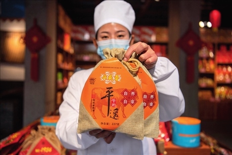 在位于山西省晉中市平遙縣的平遙古城南大街的一家平遙牛肉店內，工作人員展示一款牛肉產品（資料照片）楊晨光攝 / 本刊