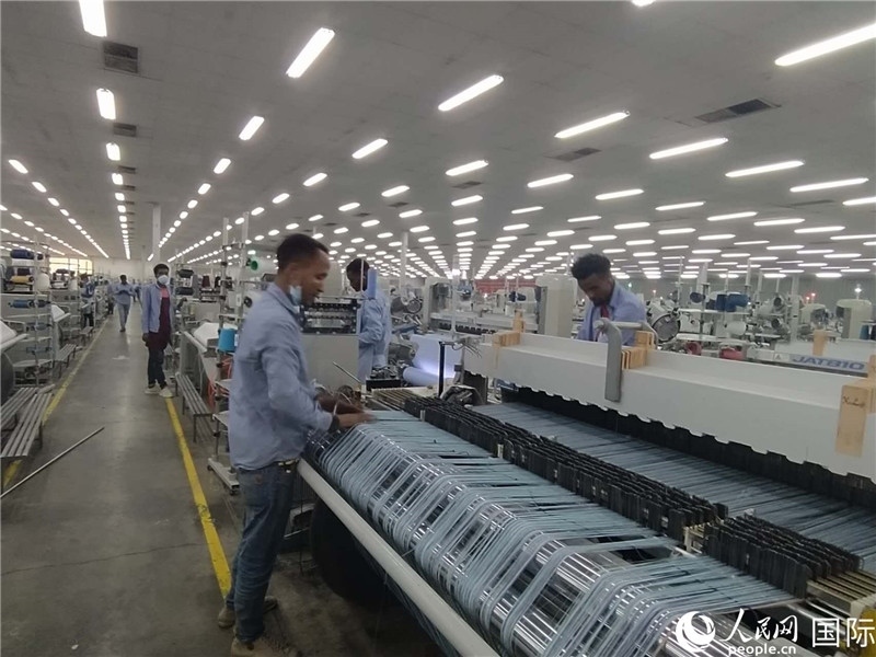無錫金茂埃塞面料廠車間內(nèi)，當(dāng)?shù)毓と苏谝唤z不茍地作業(yè)。人民網(wǎng)記者 黃培昭攝