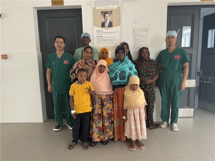 李廣（右一）和王林醫(yī)生與部分患者合影。中國(guó)援桑醫(yī)療隊(duì)供圖